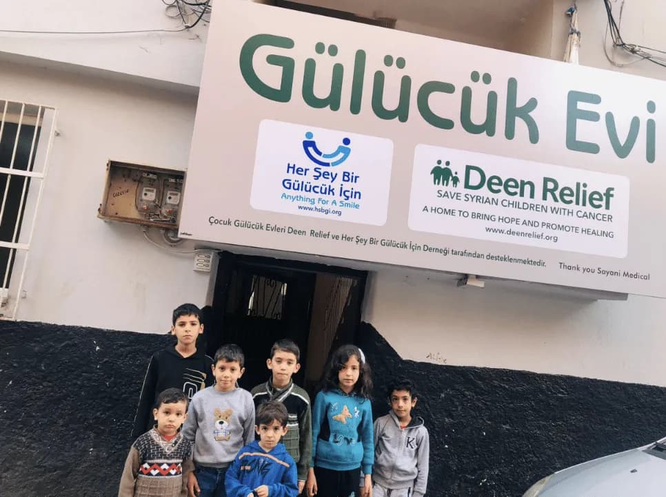 Children standing in front of the Deen Relief Gulucuk Evi care centre in Adana, Turkey